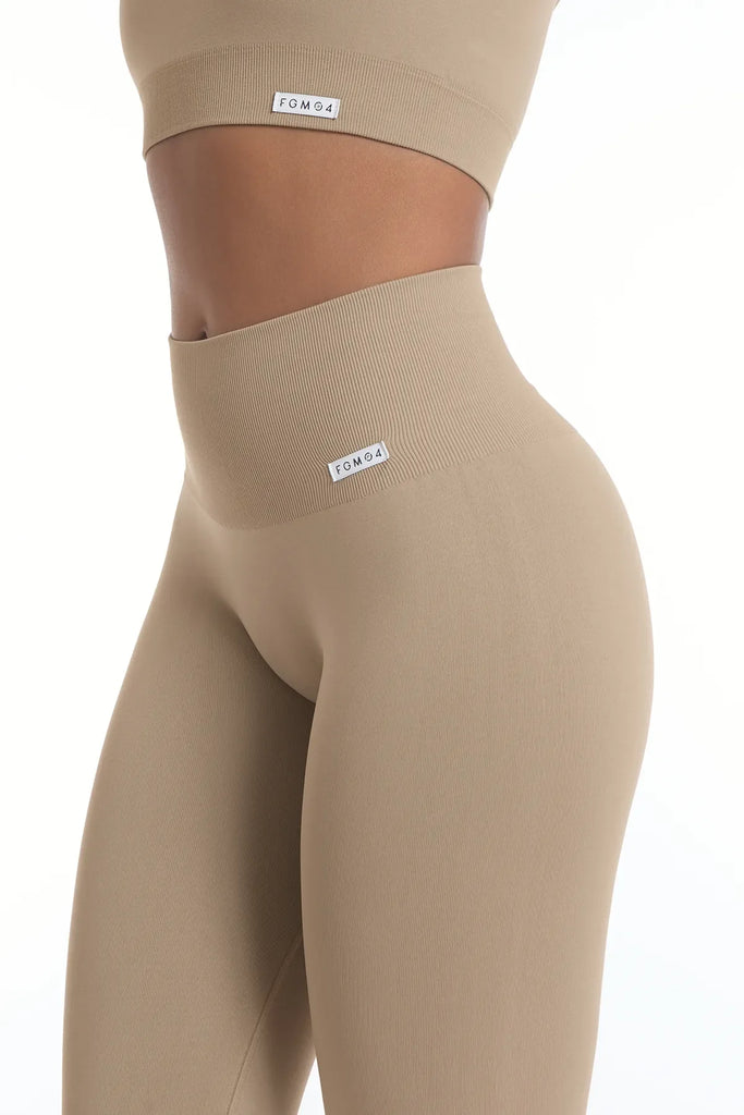 Tamprės sportui paaukštintu liemeniu kreminės